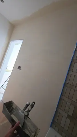 Imperfect smooth bathroom wall finish beside tile